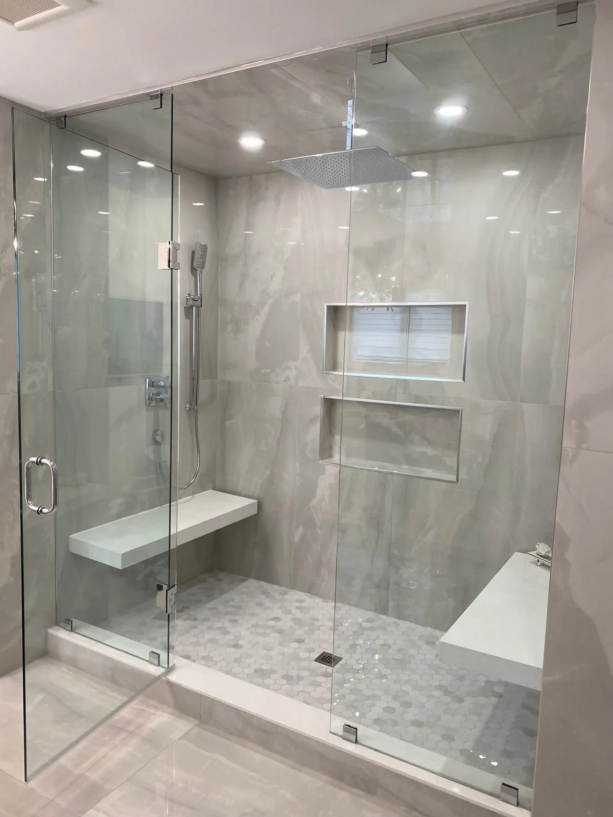 Residential shower tile installation with niche and bench