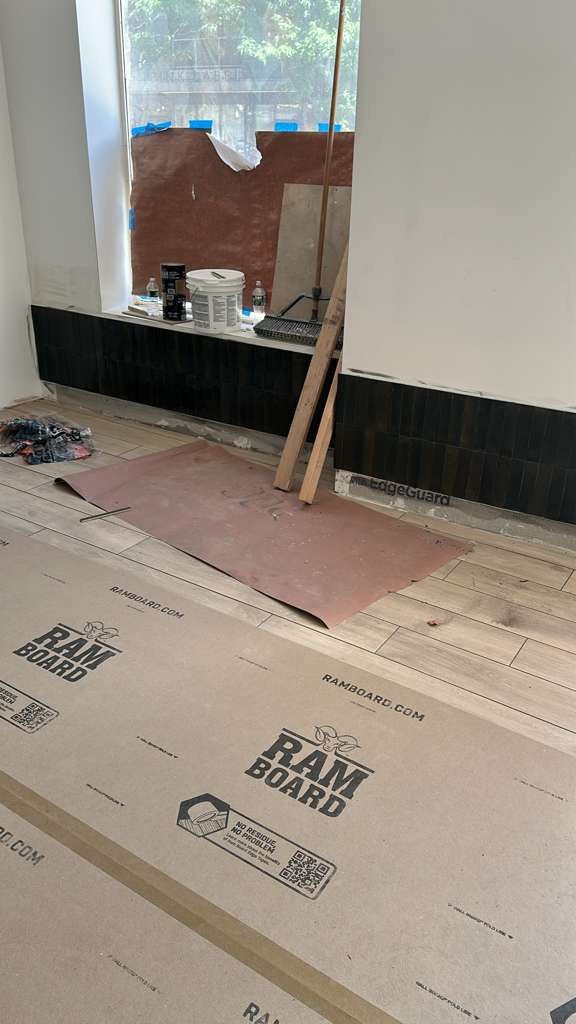 Green wall tile and wood-look floor tile during installation