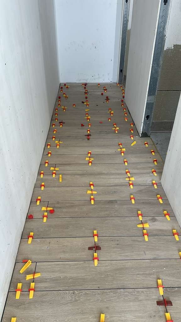 Wood-look plank tile being set with leveling clips